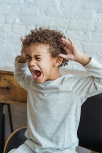 Upset young boy showing emotional distress, representing need for child psychiatry services.