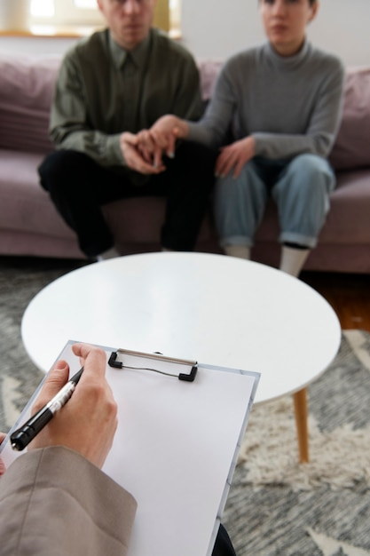 Two individuals speaking with a psychiatry provider during a psychiatric evaluation in a professional clinical setting