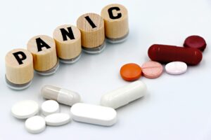 Assorted pills with wooden blocks to illustrate medication for panic disorders
