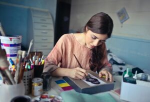 A person painting with focus