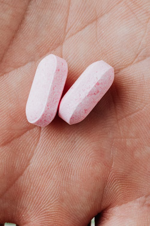 A person holding two pills 