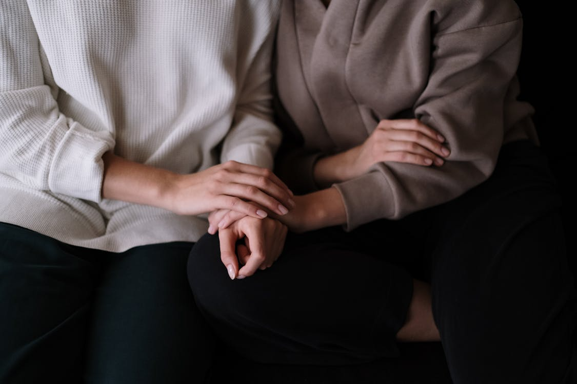 An image of people holding hands as they sit together