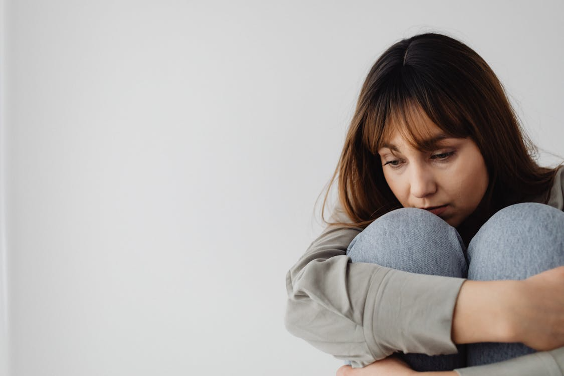 A person sitting with their knees to their chest