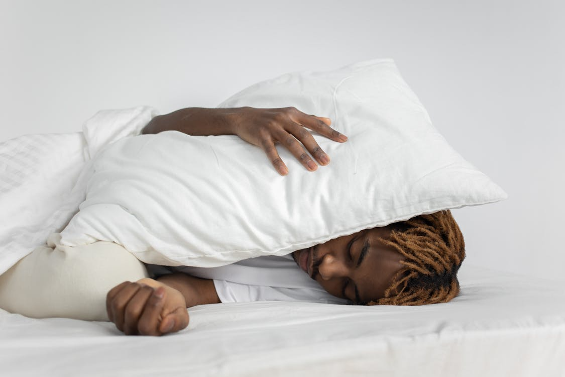 A person sleeping with a pillow to their head
