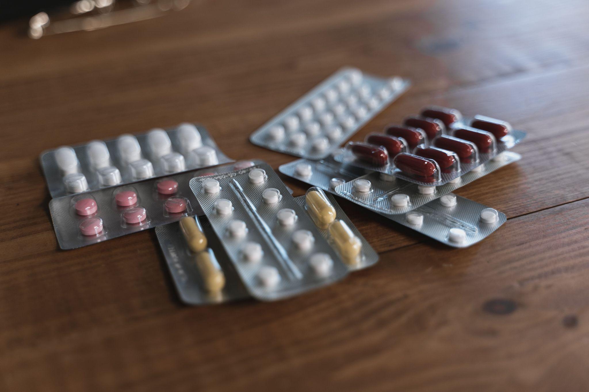 different packs of medicines on a wooden surface